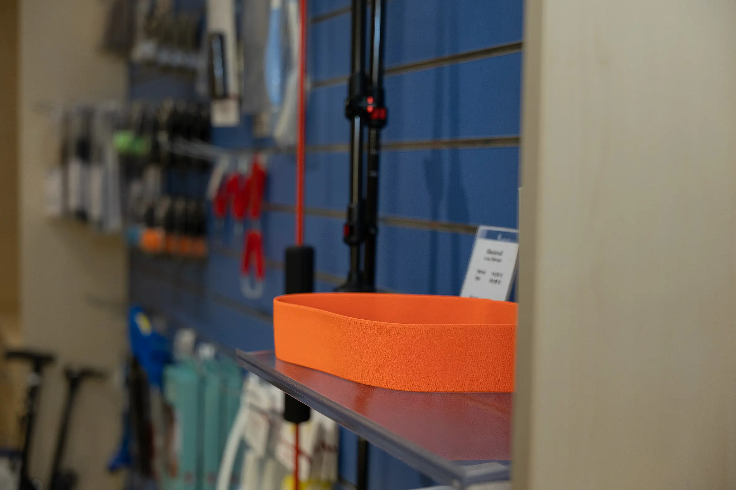 Regalansicht im Sanitätshaus mit einem orangefarbenen Hilfsmittel im Vordergrund und weiteren Produkten im Hintergrund.