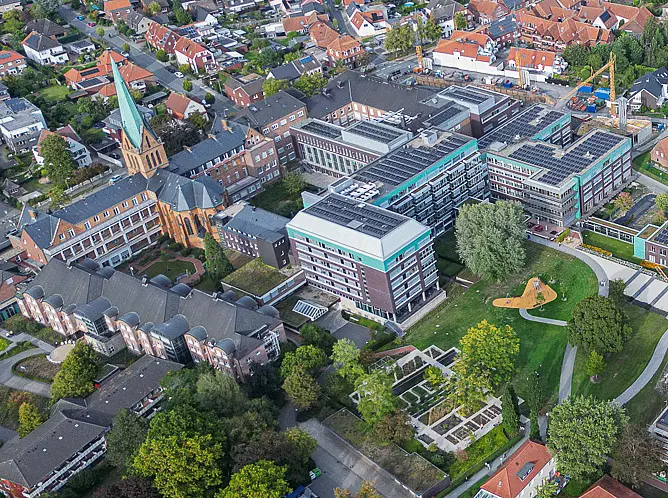 Aktuelle Drohnenaufnahme des Campus des St. Josef-Stifts Sendenhorst mit bestehenden Gebäuden, Neubauten und Baustelle im Stadtumfeld.