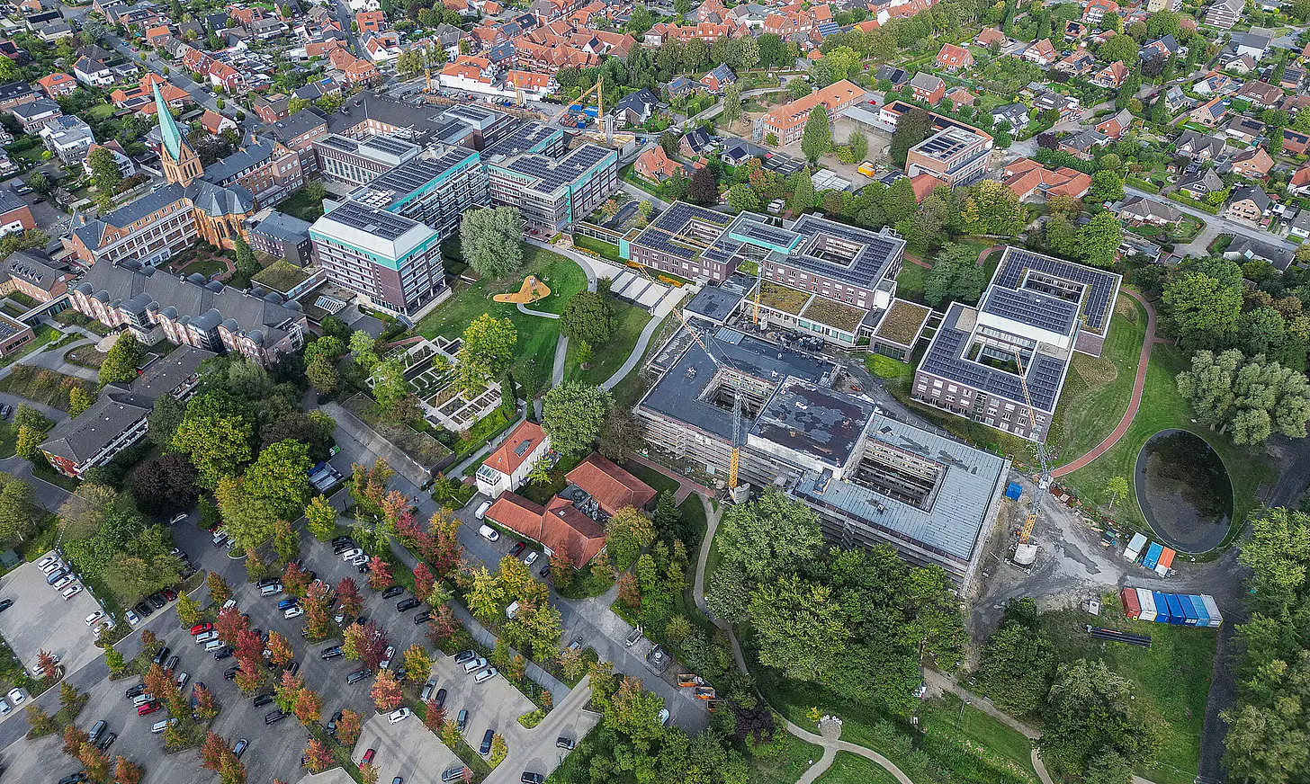 Aktuelle Drohnenaufnahme des Campus des St. Josef-Stifts Sendenhorst mit bestehenden Gebäuden, Neubauten und Baustelle im Stadtumfeld.