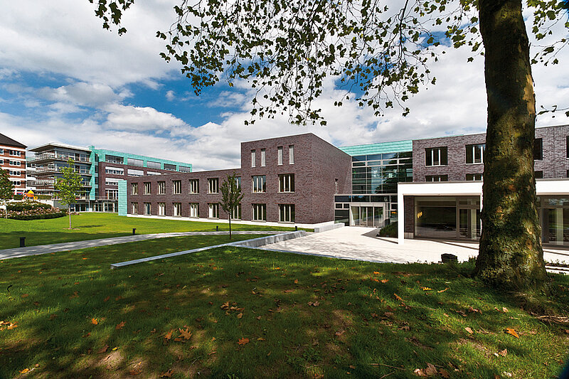 Moderner Klinikbau mit Glasfassade und Grünflächen auf dem Campus des St. Josef-Stift Sendenhorst.
