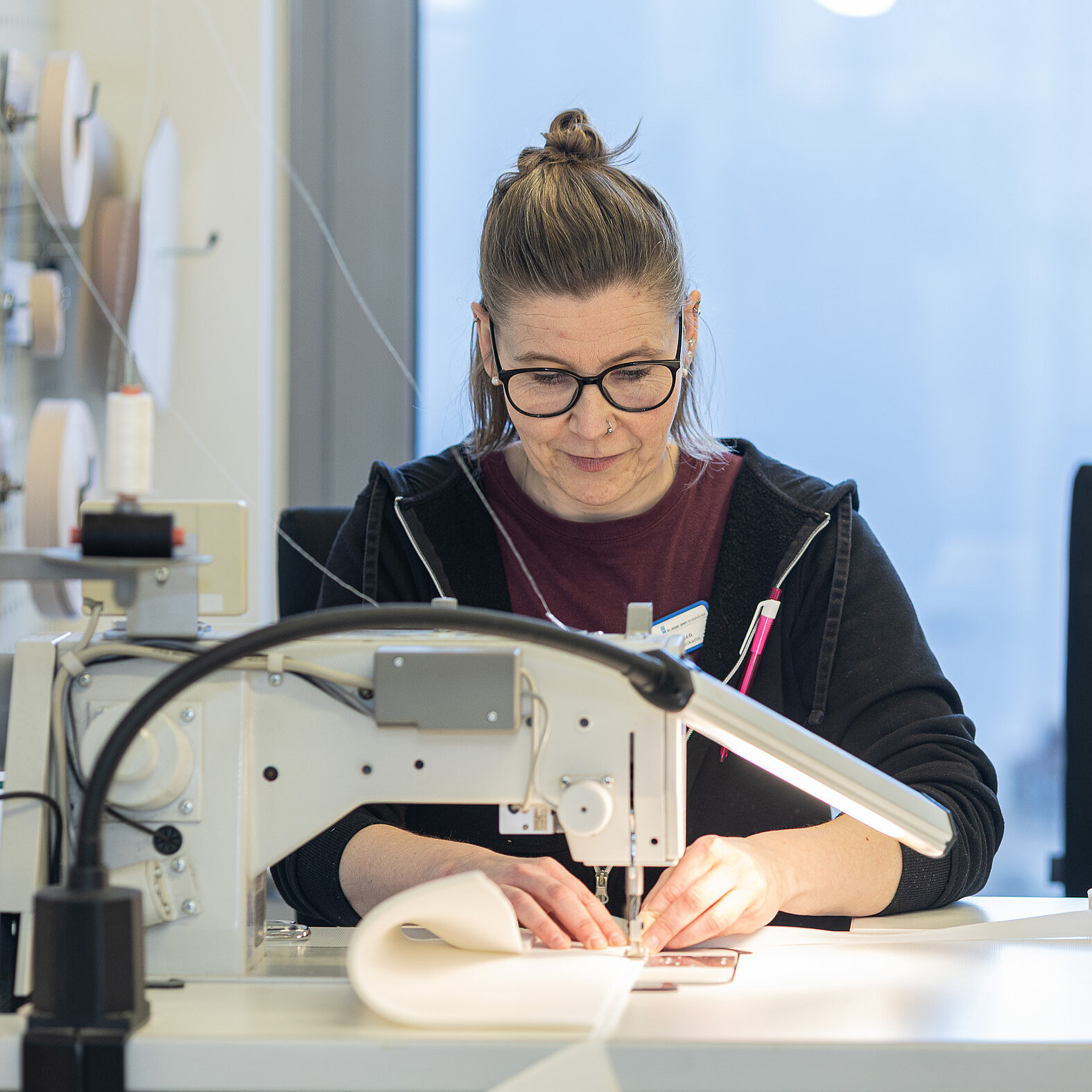 Mitarbeiterin näht ein orthopädietechnisches Bauteil an einer Industrienähmaschine.