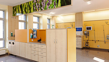 Heller Bereich der Intensivobservation mit Pflegearbeitsplatz, Einbauschränken und medizinischer Infrastruktur an der Wand.