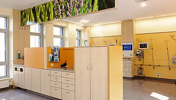 Heller Bereich der Intensivobservation mit Pflegearbeitsplatz, Einbauschränken und medizinischer Infrastruktur an der Wand.