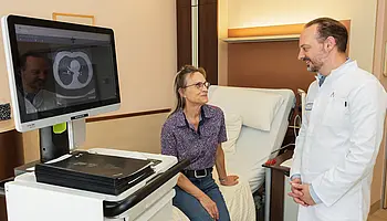 PD Dr. med. Peter Korsten sitzt einer Patientin gegenüber und hört ihr aufmerksam zu.