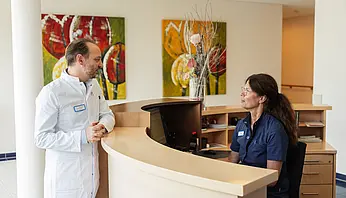 Dr. PD Peter Korsten spricht am Empfang der Station mit einer Fachkrankenpflegerin über organisatorische Abläufe.