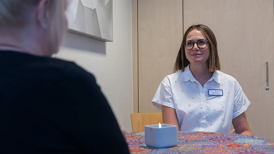 Ein Foto über die Schulter einer Patientin, die im Rahmen der Seelsorge mit Alicja Skowasch spricht.