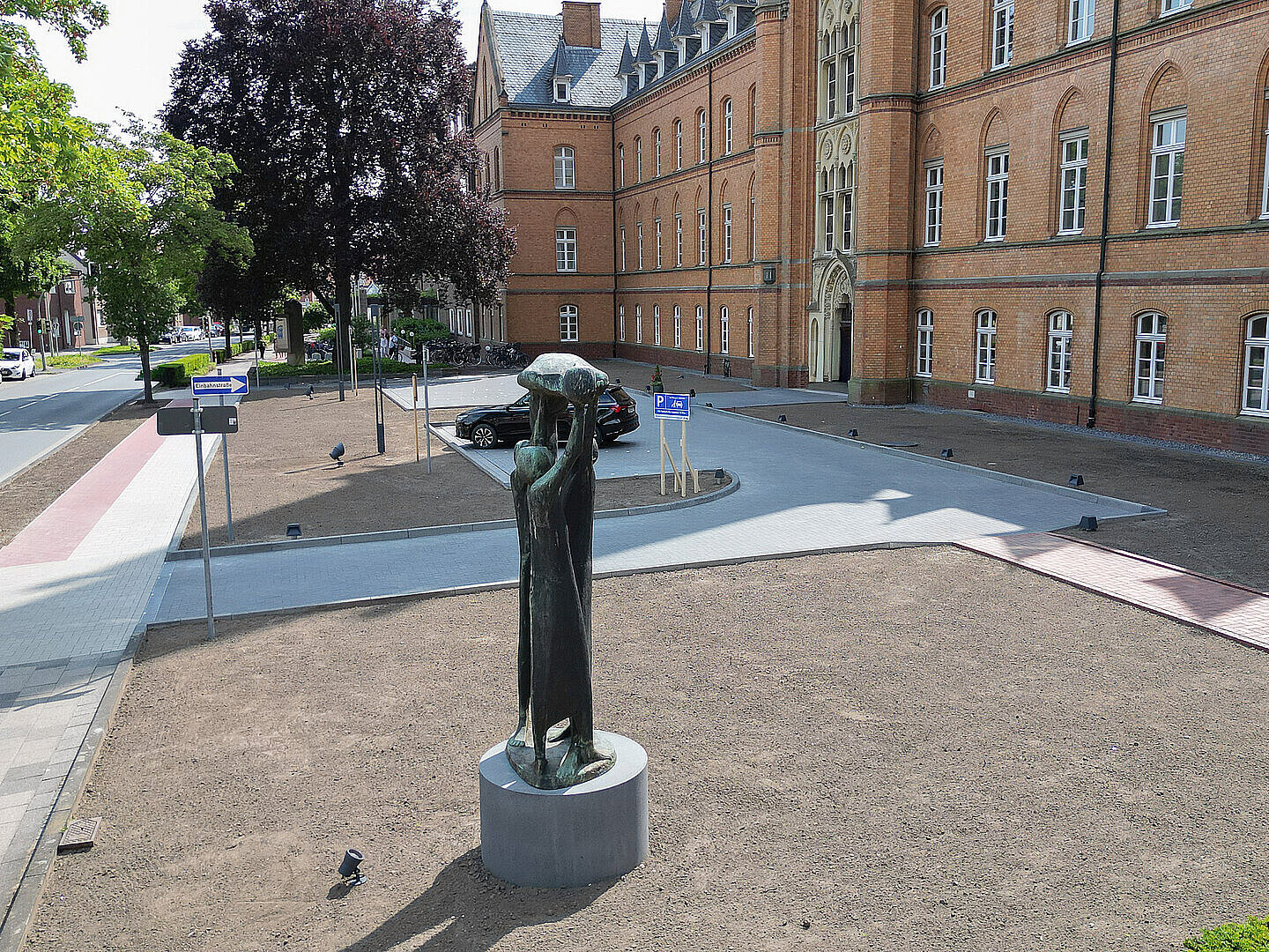 Zufahrt mit Gehweg und Beschilderung vor einem Backsteingebäude des St. Josef-Stift Sendenhorst.