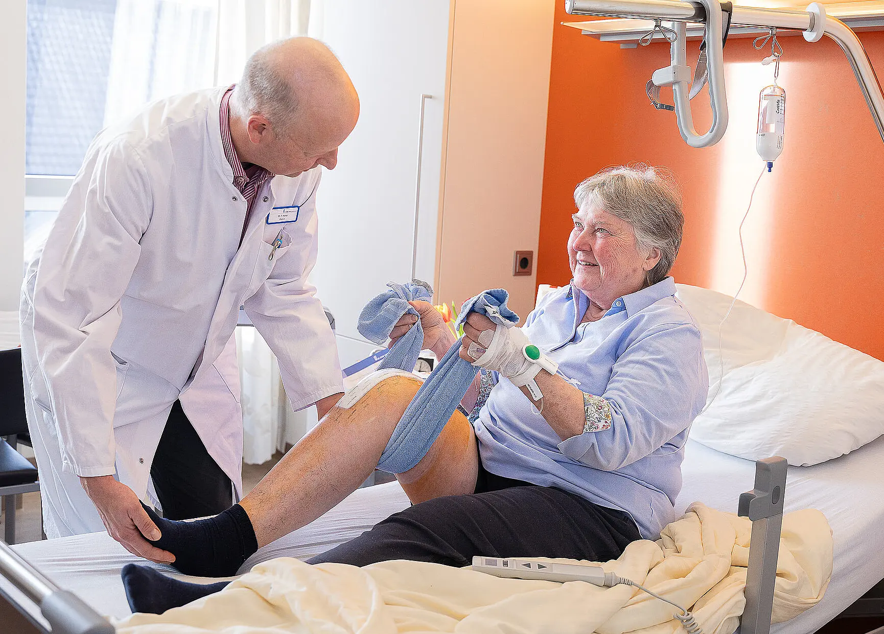 Aktivierende Pflege: Eine Patientin trainiert ihre Beinbeweglichkeit mit Unterstützung des ärztlichen Personals.