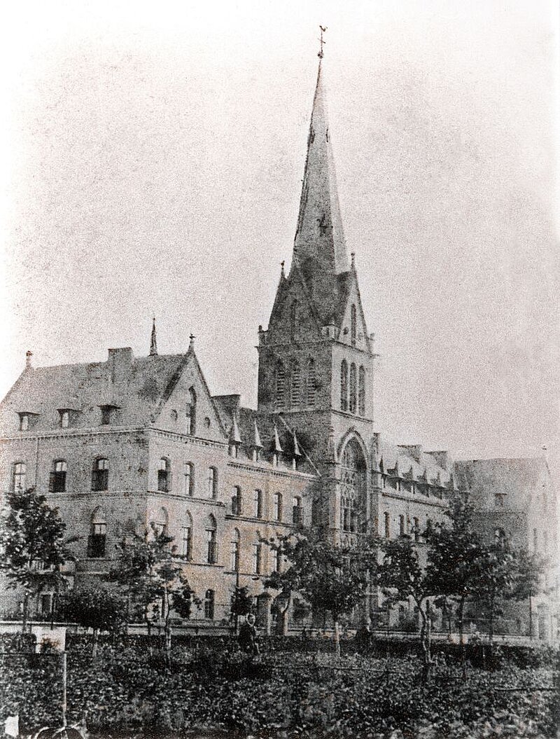 Historische Ansicht des St. Josef-Stift Sendenhorst mit markantem Kirchenbau und umliegenden Klinikgebäuden.
