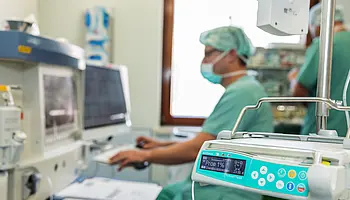 Chefarzt Dr. med. Matthias Boschin sitzt an einem Arbeitsplatz.