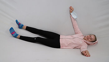 Jugendliche liegt entspannt in einer Hängematte in einem Therapieraum.