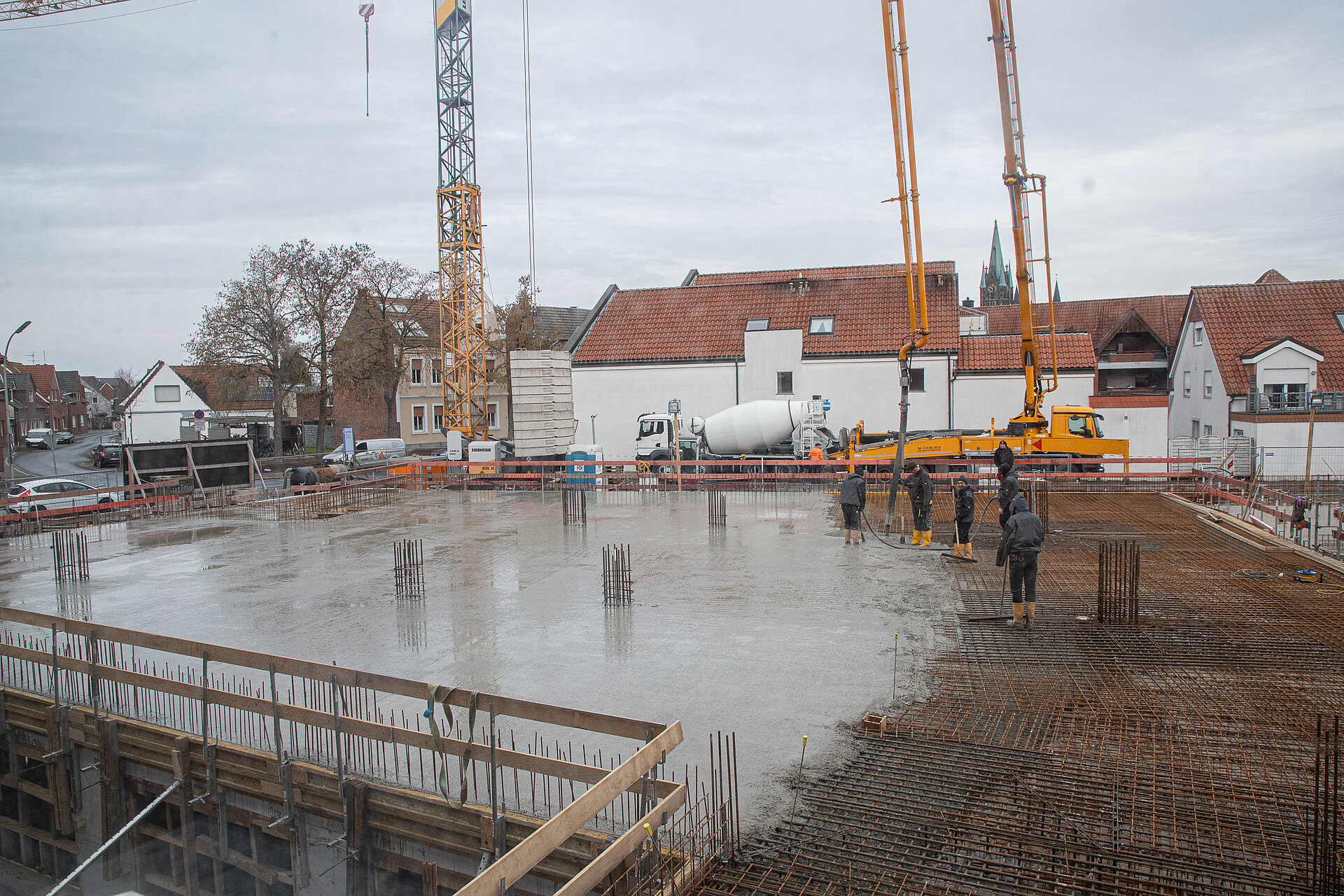 Bauarbeiter stehen auf einem großen Feld mit frischem Beton.