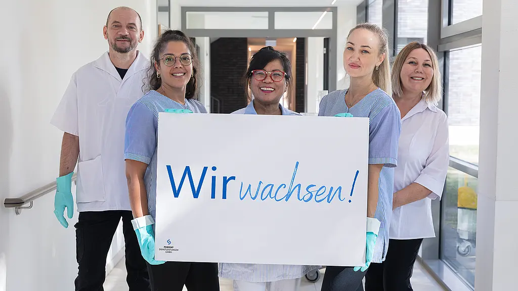 Ein Foto von hauswirtschaftliche Mitarbeiterinnen und Mitarbeitern, die ein Schild mit dem Slogan in den Händen halten.