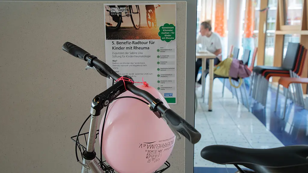 Ein Plakat der Tour hängt hinter einem abgestellten Fahrrad auf Station.